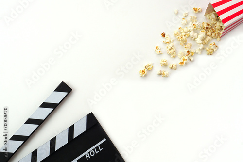 Clapperboard or movie slate black color with popcorn on white background. Cinema industry, video production and film concept.