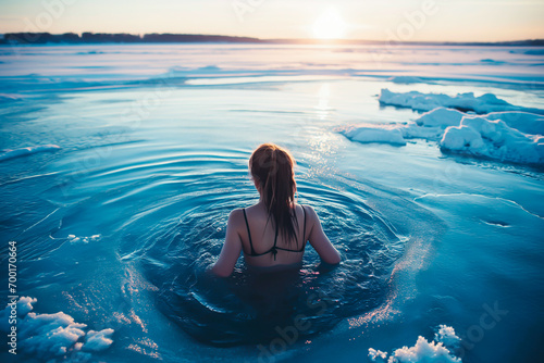 Woman in icy water during winter, polar bear plunge into a hole in the ice. Winter bathing. Shallow field of view.
 photo