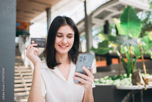 Happy woman using smart phone for online shopping. Hand of woman holding credit card. Online e-banking app  Internet banking