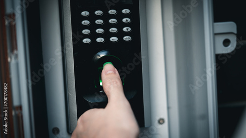Close up hand of woman press down the finger on fingerprints scan machine for unlock door security system.