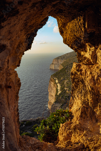 Cliff in Malta during sunset, through a natural arch Mediterranean Sea