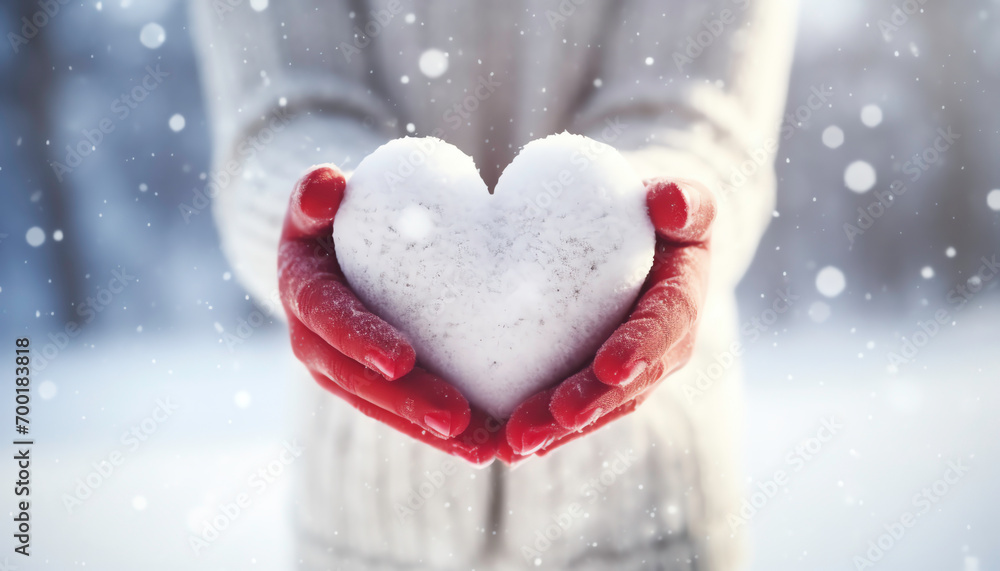 a person holding a heart shaped snowball