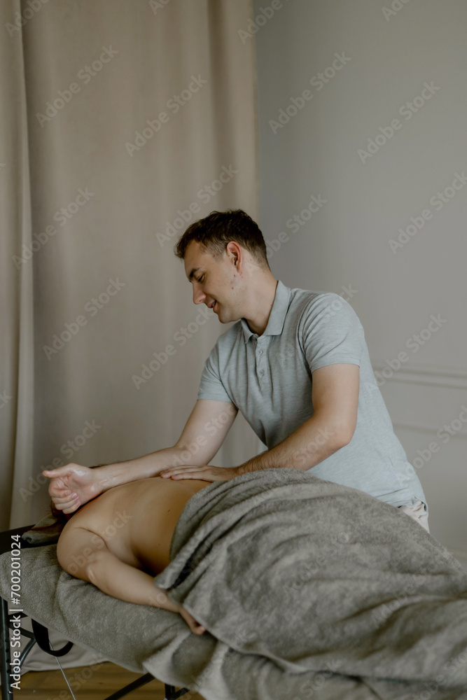 Relaxing massage in the salon. Male masseur massages his back Relaxing massage in the salon. Male masseur massages his back
