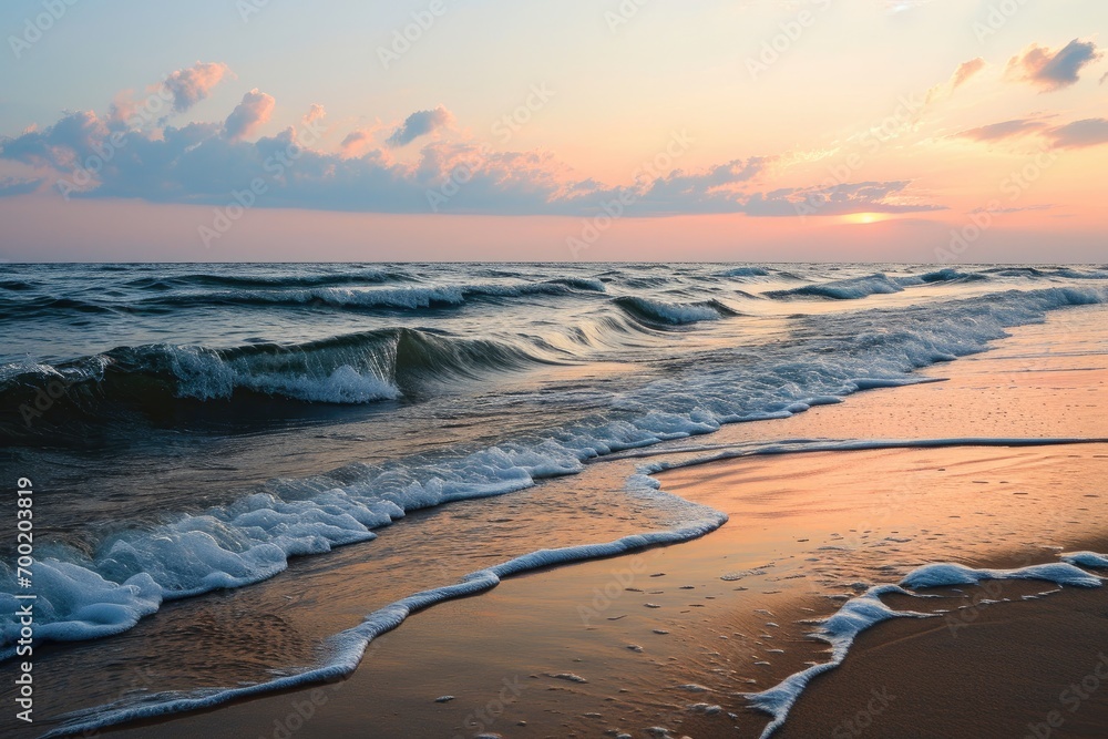 Sunset over a serene beach with smooth waves and pastel sky.