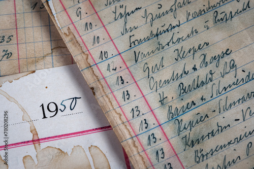 Closeup of vintage grungy, ledger paper with handwriting in ink and coffee stains.  photo