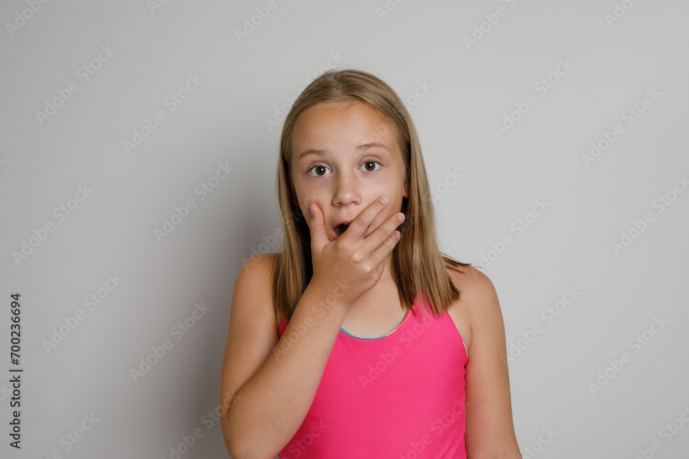 Surprise. Pretty young girl portrait. Little kid posing on light gray studio background Surprise. Pretty young girl portrait. Little kid posing on light gray studio background
