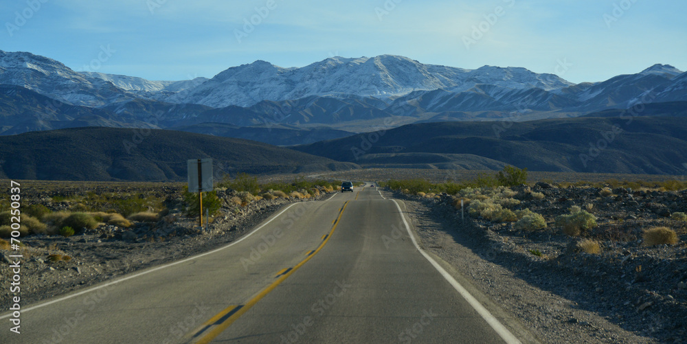 Naklejka premium Straight Road in the California desert, going into the mountains near Death Valley National Park