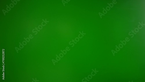A man knocks with his hand (open) on a green background photo
