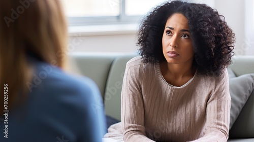 Photo of a young African American woman at an appointment with a psychologist. The psychotherapist listens carefully to the patient’s story.