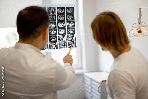 Man on medical appointment with urologist, doctor shows an X-ray of the patient's pelvis. Concept of men's health photo