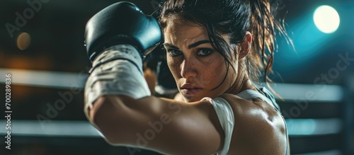 Female boxer training in gym with hand wrap.