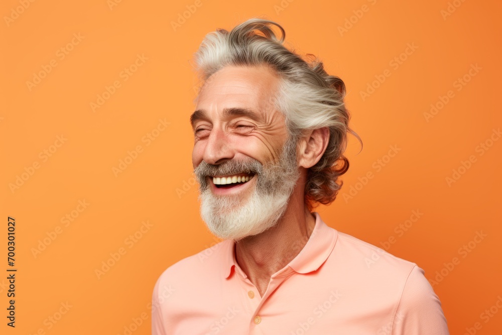 Portrait of happy senior man with grey hair and beard, isolated on orange background Portrait of happy senior man with grey hair and beard, isolated on orange background