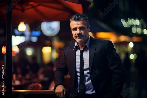Handsome middle-aged man sitting in a restaurant at night