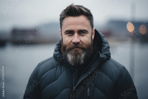 Portrait of a handsome bearded man in a winter jacket on the street