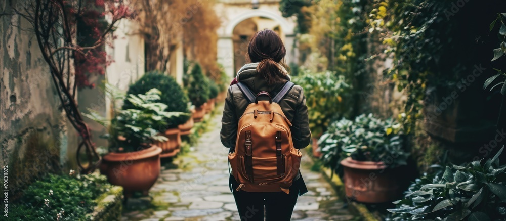 College student, carrying a backpack, explores campus gardens for studying and personal development.