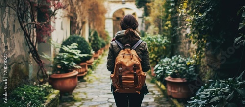 College student, carrying a backpack, explores campus gardens for studying and personal development. photo