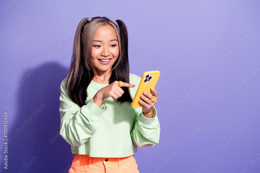 Photo of chinese blogger youngster girl select option in online using smartphone order pizza isolated over purple color background Photo of chinese blogger youngster girl select option in online using smartphone order pizza isolated over purple color background