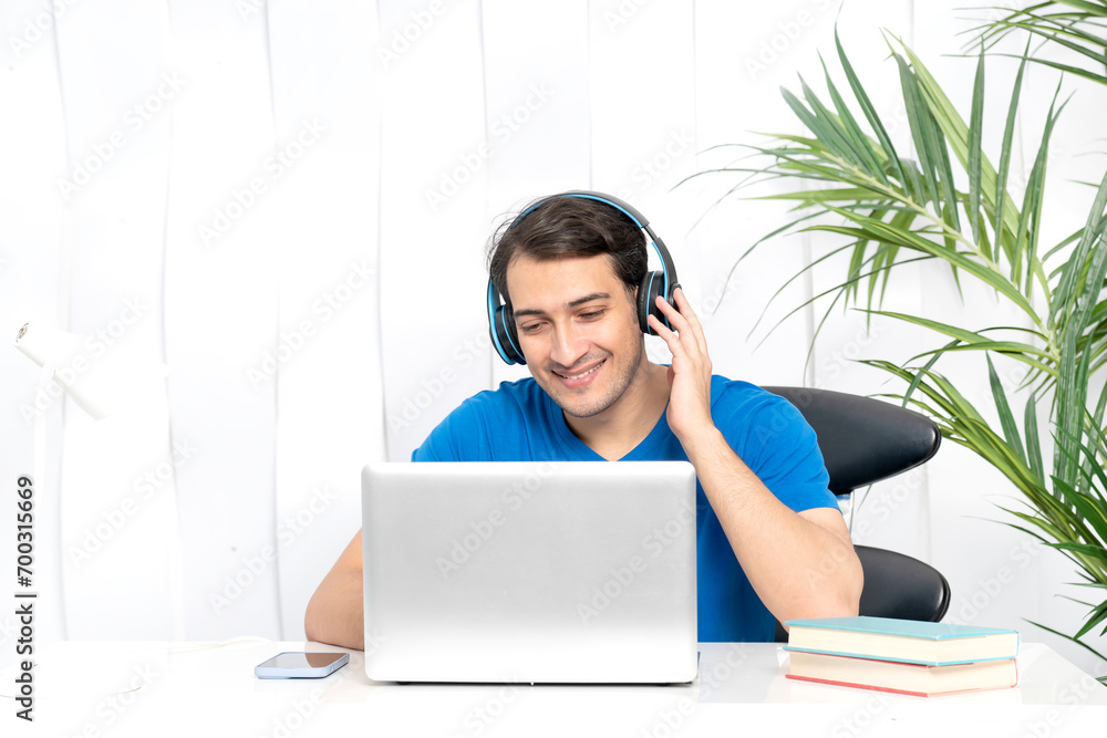 Young handsome man in headphones studying online at home. Distance education concept Young handsome man in headphones studying online at home. Distance education concept