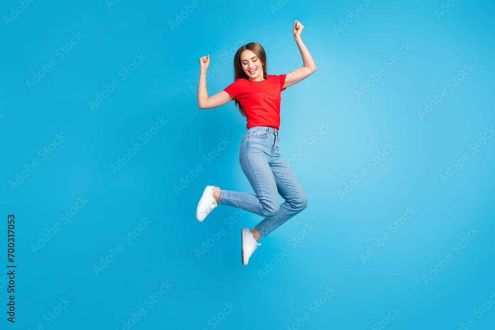 Full length photo of cheerful glad girl dressed trendy clothes fly air with raise hands isolated on blue color background