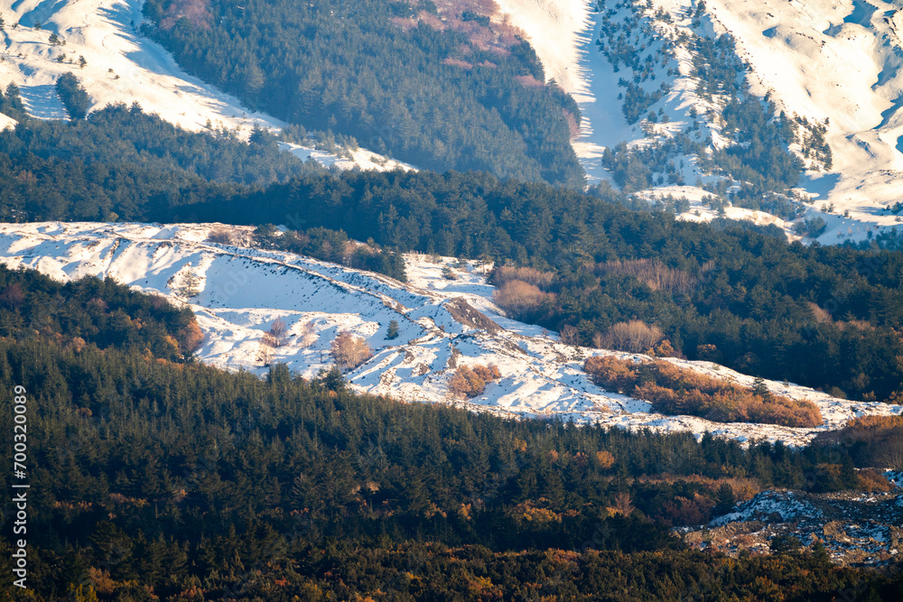 Bronte town under the snowy and majestic volcano Etna and a cloudy blue sky