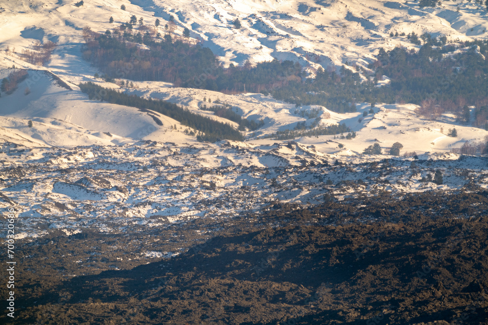 Bronte town under the snowy and majestic volcano Etna and a cloudy blue sky