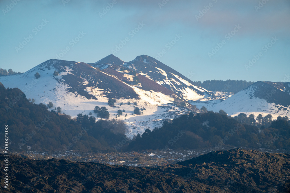 Bronte town under the snowy and majestic volcano Etna and a cloudy blue sky