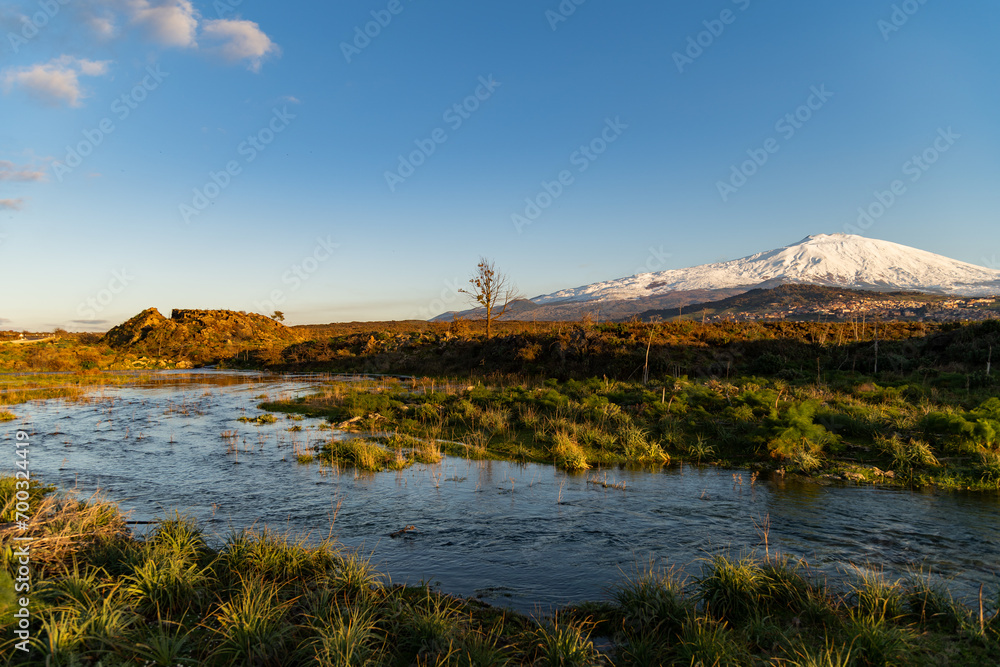 A seasonal river flows under the massive snowcovered Etna volcano. Favare Santa Venera 