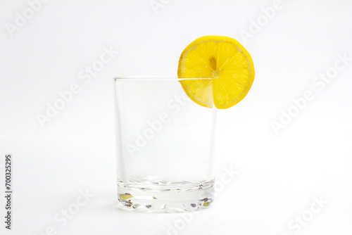 Glass with a transparent cocktail and lemon