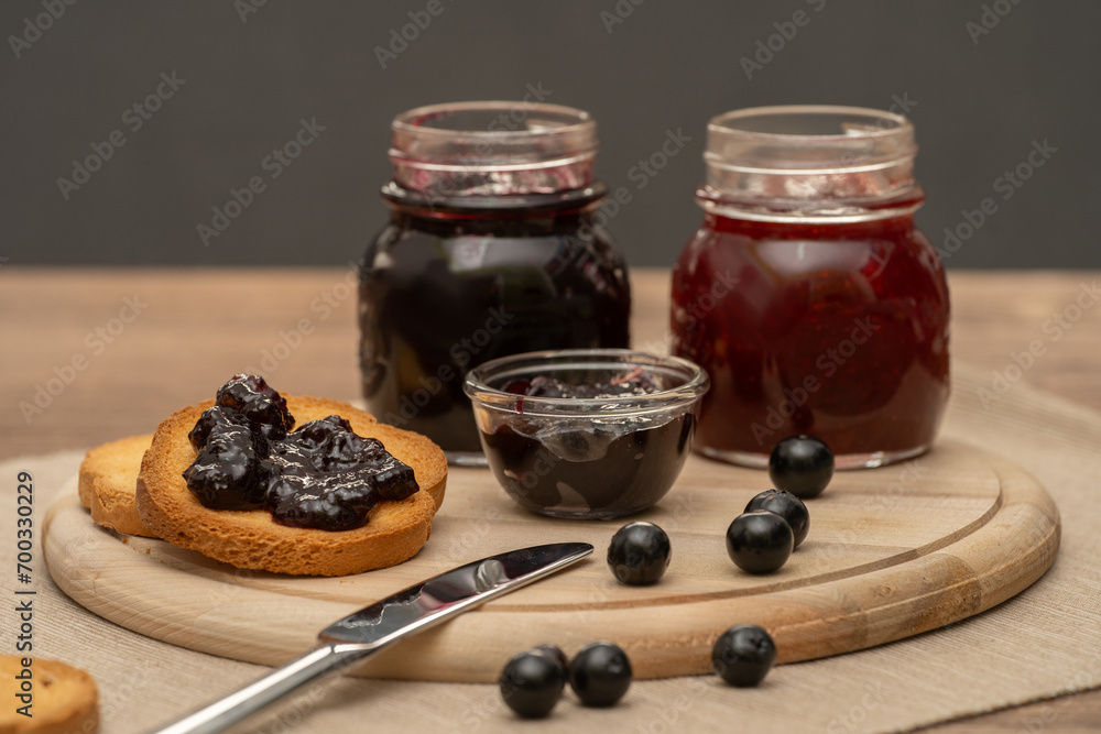 Blueberry jam on wooden plate with knife and bread. Made in Sicily