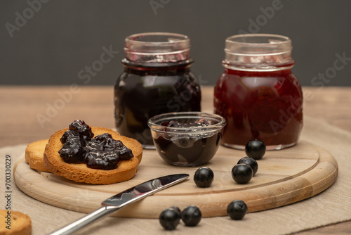 Obraz na płótnie Blueberry jam on wooden plate with knife and bread. Made in Sicily w salonie