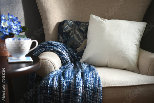Plain canvas throw pillow suitable for mock up mockup on a chair with blue throw blanket - your design, message or logo photo