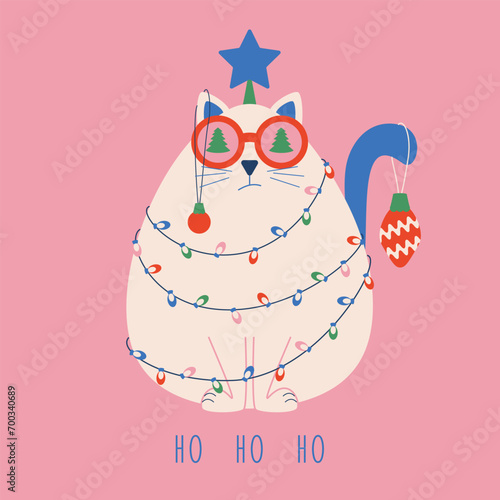 Christmas card with a funny cat wrapped in a garland and toys with a star on its head and text ho ho ho.