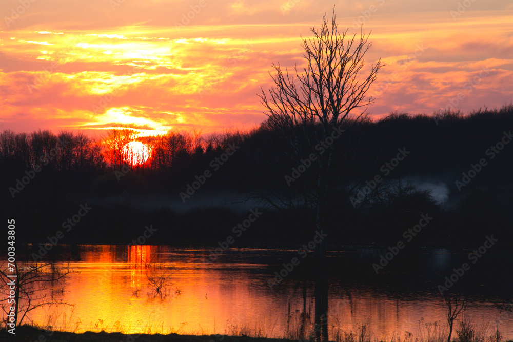 Sunset by a small lake on a day in March Sunset by a small lake on a day in March