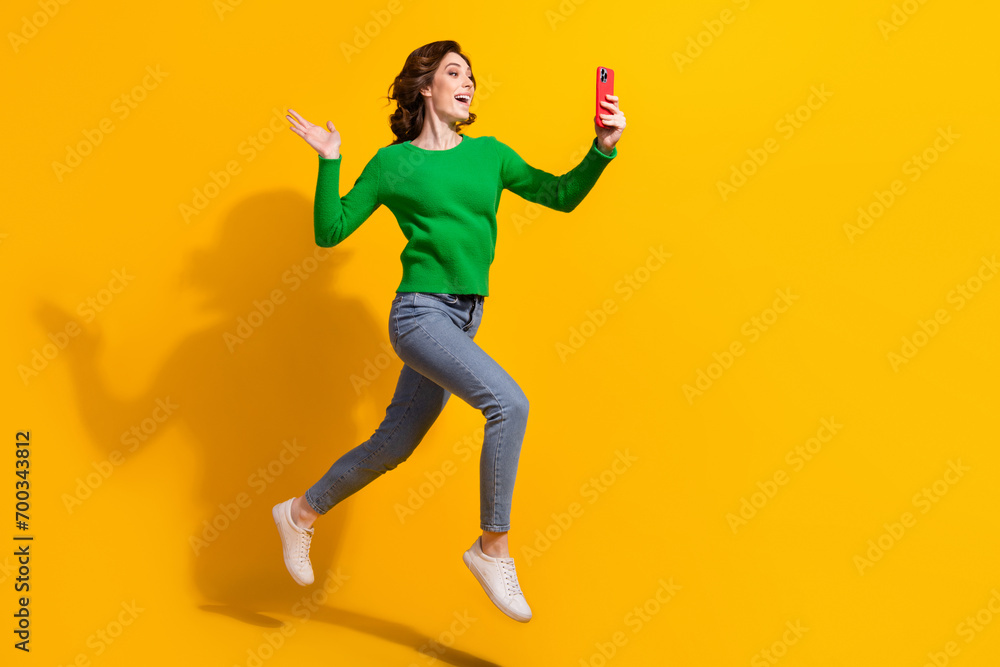 Full body photo of energetic lifestyle blogger girl recording video self portrait friendly waving palm isolated on yellow color background