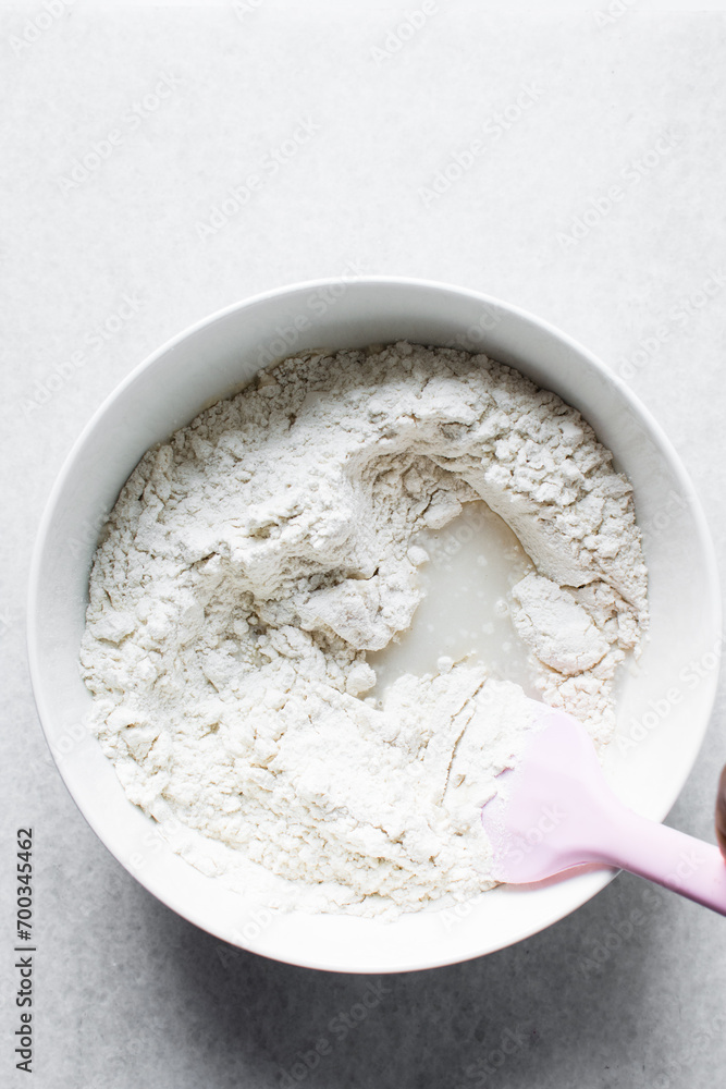 Partially mixed bread dough, water in the middle of flour, process of making focaccia bread Partially mixed bread dough, water in the middle of flour, process of making focaccia bread