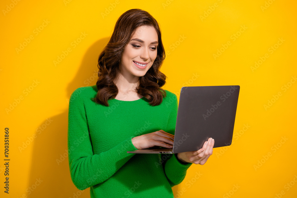 Naklejka premium Portrait of gorgeous cheerful person toothy smile use laptop coworking isolated on yellow color background