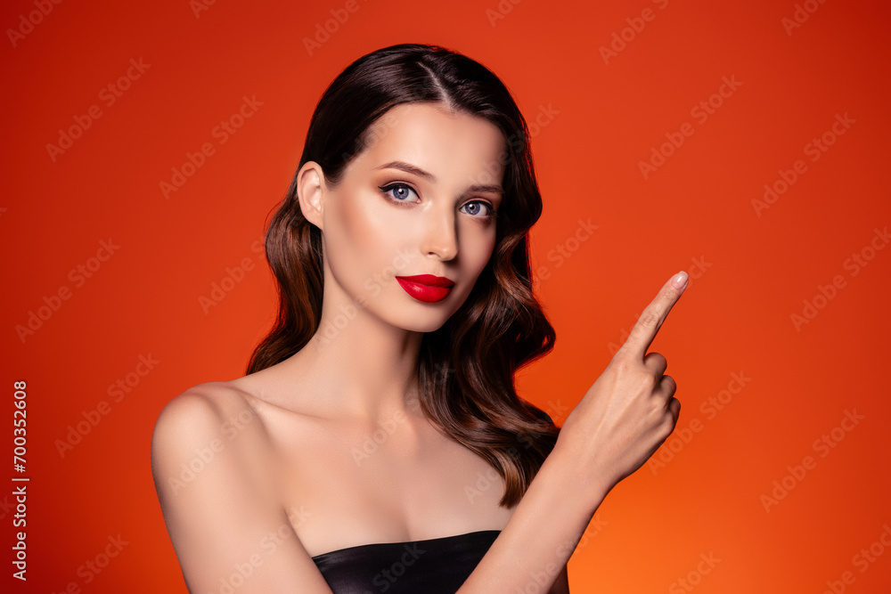 Photo of attractive lady in vogue cocktail dress demonstrate on orange empty space beauty product fashion promo Photo of attractive lady in vogue cocktail dress demonstrate on orange empty space beauty product fashion promo
