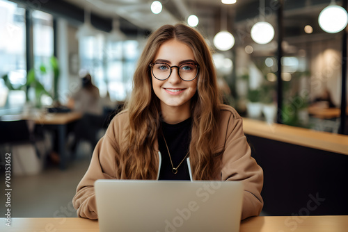 Young Adult Businesswoman Using Laptop at Office Table
