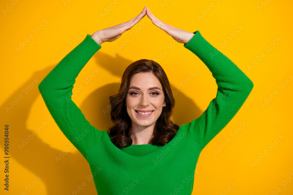 Photo of lovely cute glad woman real estate agency worker two hand above head demonstrate roof isolated on yellow color background