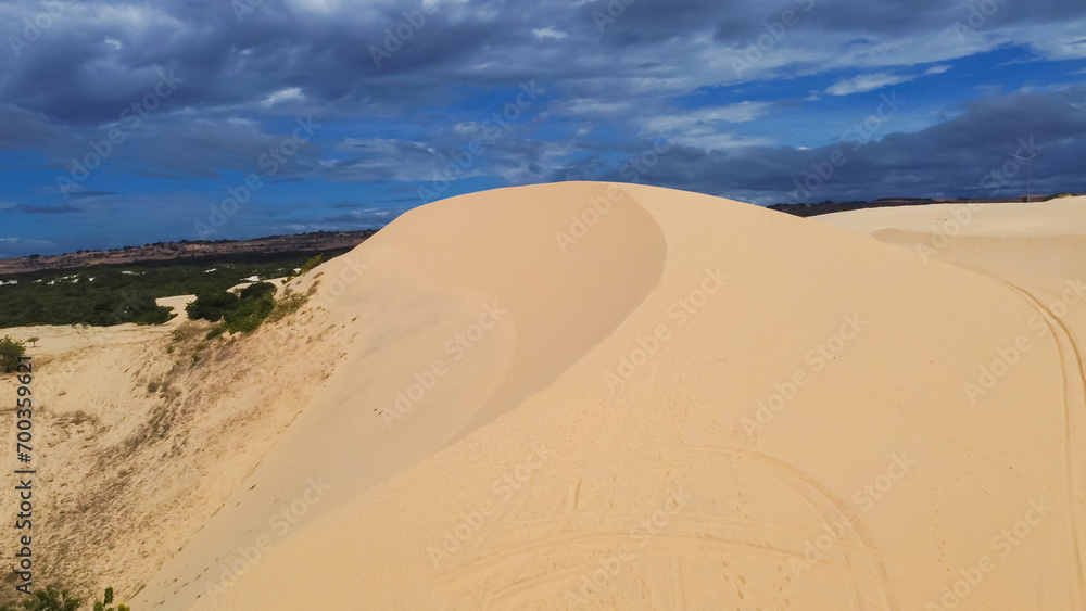Scenic steep large white sand dunes, curved tracks and desert-like landscape with low scrub vegetation at Bau Trang, Bac Binh District, Binh Thuan Province, Vietnam, travel destination