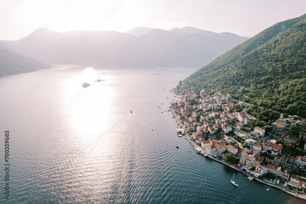 Sea sparkling in the sun off the coast of Perast between the mountains. Montenegro. Drone
