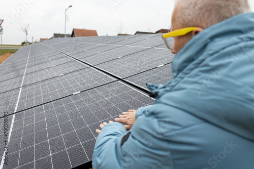 Mature man with solar power panels. Renewable energy. Sustainable resources.