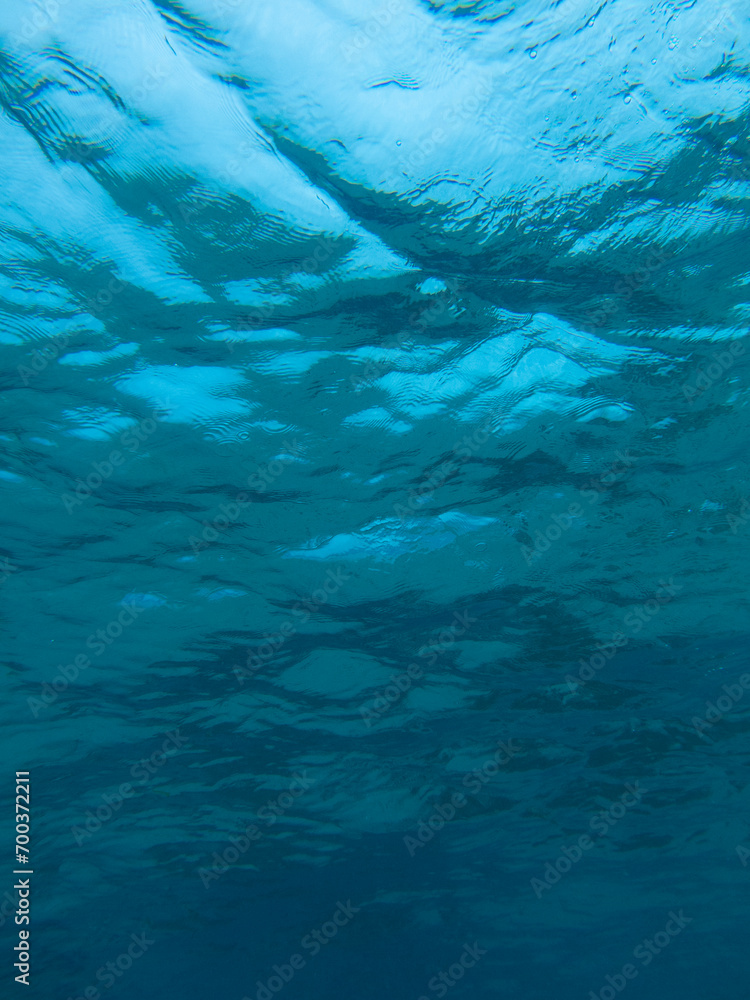 Water surface from underwater, blue background, ripples
