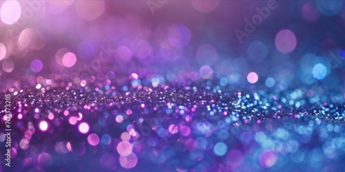 A close-up of a glittery surface with sparkling silver, purple, and blue lights creating a bokeh effect.