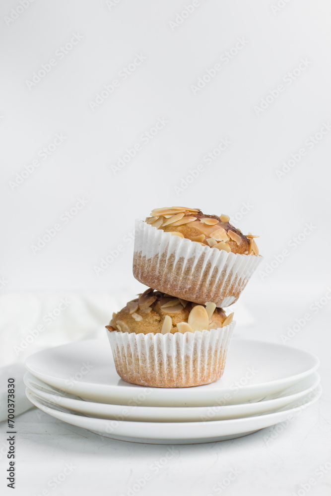 vanilla almond muffins on a white plate, homemade bakery style almond muffins on a white background vanilla almond muffins on a white plate, homemade bakery style almond muffins on a white background
