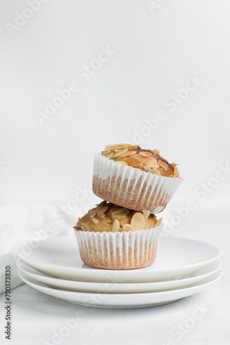 vanilla almond muffins on a white plate, homemade bakery style almond muffins on a white background