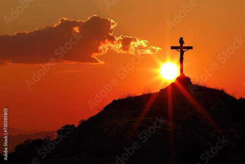 A fiery orb of the setting sun aligns perfectly with a cross on a hill, a dramatic and powerful visual of the light overcoming darkness.
