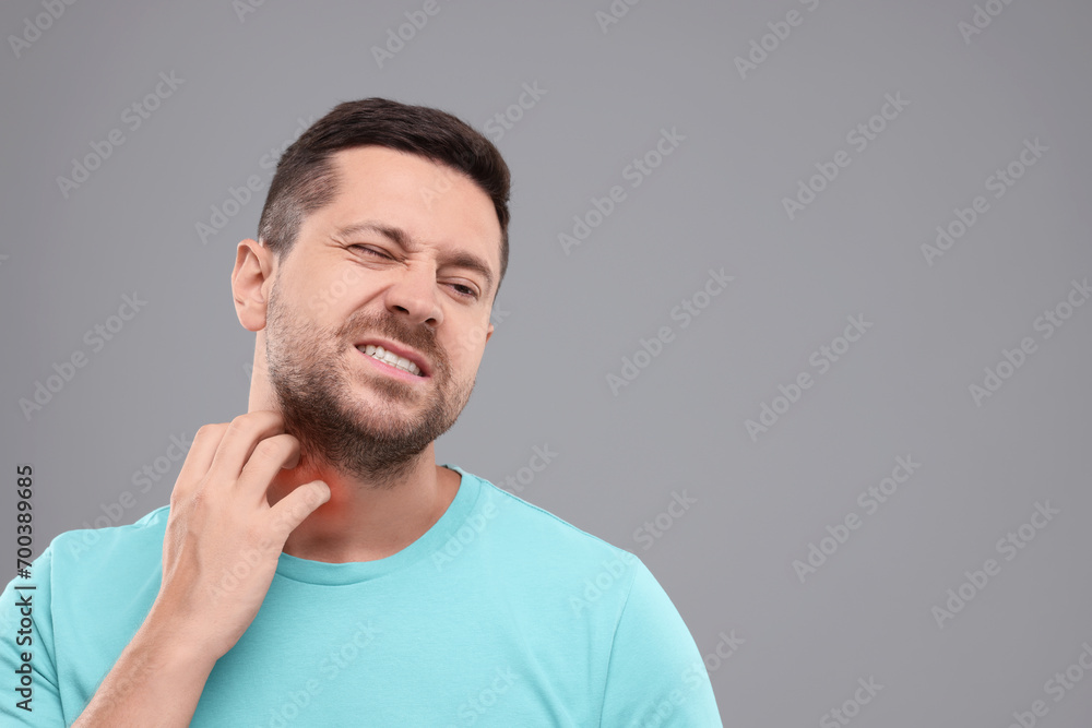 Allergy symptom. Man scratching his neck on light grey background. Space for text Allergy symptom. Man scratching his neck on light grey background. Space for text
