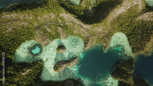 Drone shot following boat around a cliffs and lagoons, turquoise water in Raja Ampat photo