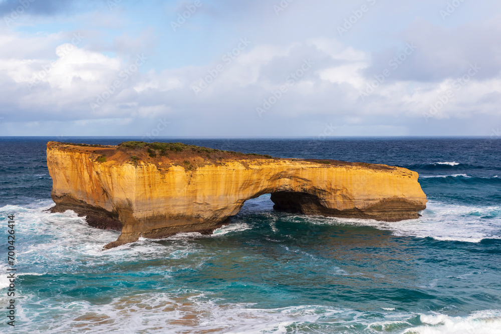 Photograph of the rock formation London Bridge against a stormy sky near Port Campbell on the rugged coastline along the Great Ocean Road in Victoria in Australia